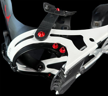 White snowboard binding highback with red bolts, black straps, close-up angle