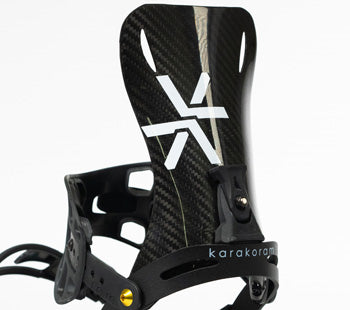 Close-up of black carbon fiber snowboard binding highback with white logo