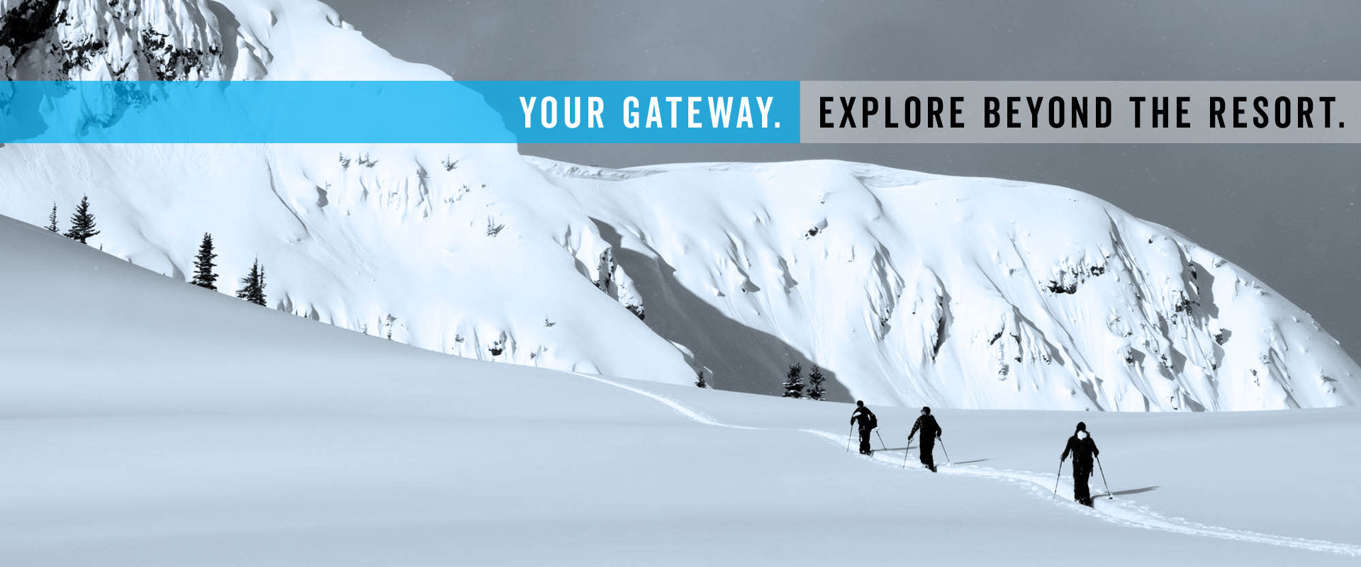 Three backcountry skiers trekking uphill across snowy mountain ridge