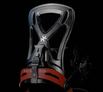 Black snowboard binding highback with red straps, close-up angle