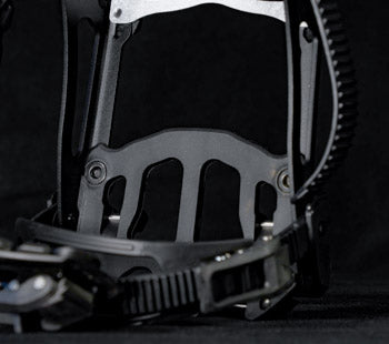 Close-up of black snowboard binding highback with ratchet strap buckle