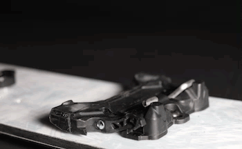 Black rear derailleur mechanism resting on light gray surface