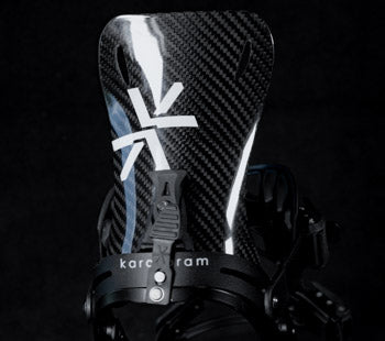 Close-up of black carbon fiber snowboard binding highback with logo