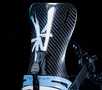 Close-up of black carbon fiber snowboard binding highback with ratchet buckle