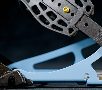 Close-up of black snowboard binding with light blue highback and buckles