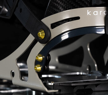 Close-up of snowboard binding highback with gold hardware and carbon straps