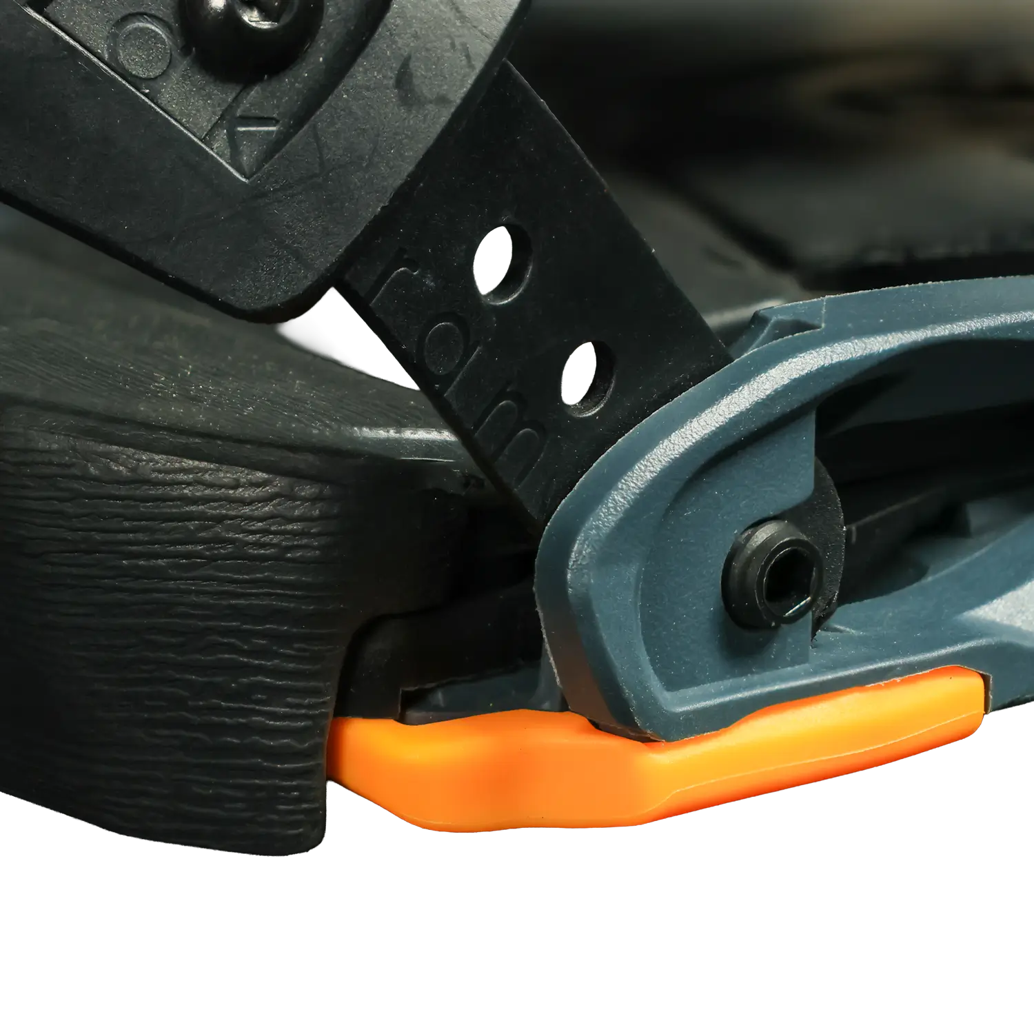 Close-up of ski binding hinge mechanism with orange plastic heel piece