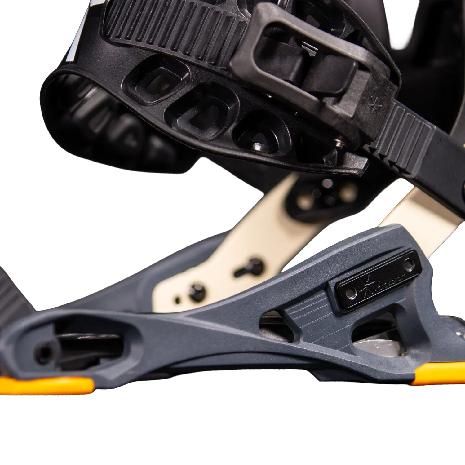 Close-up of black snowboard binding highback with gray baseplate, orange accents