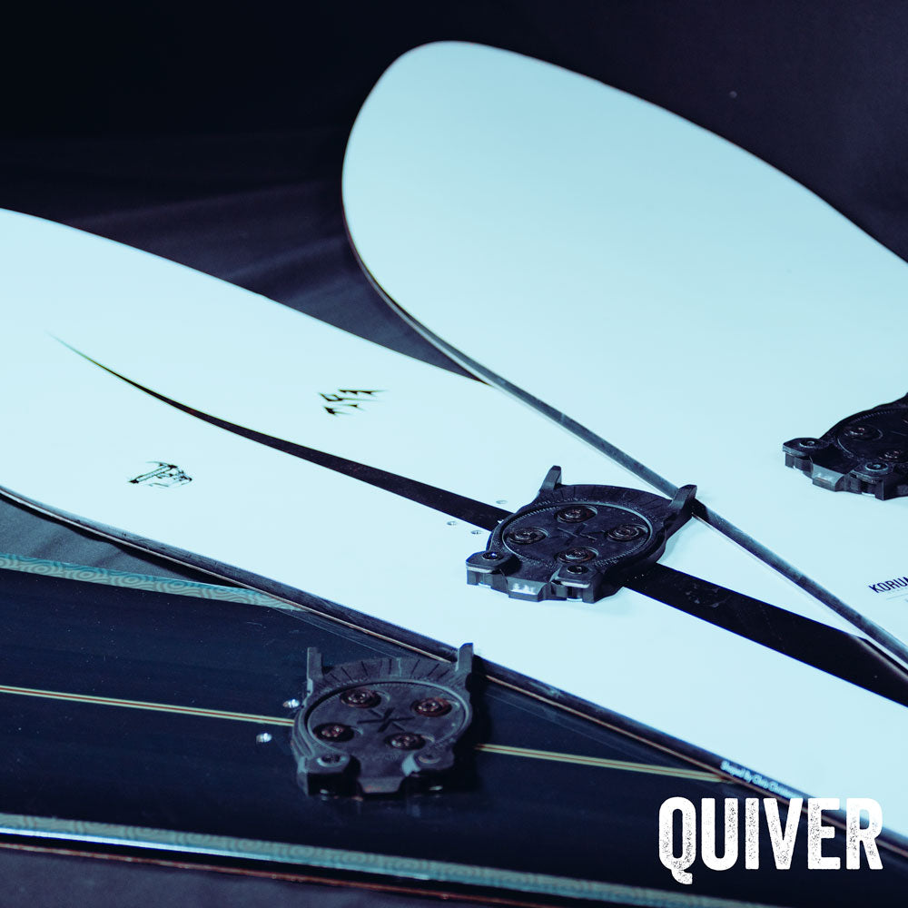 Stacked snowboards with black binding discs, close-up angled view
