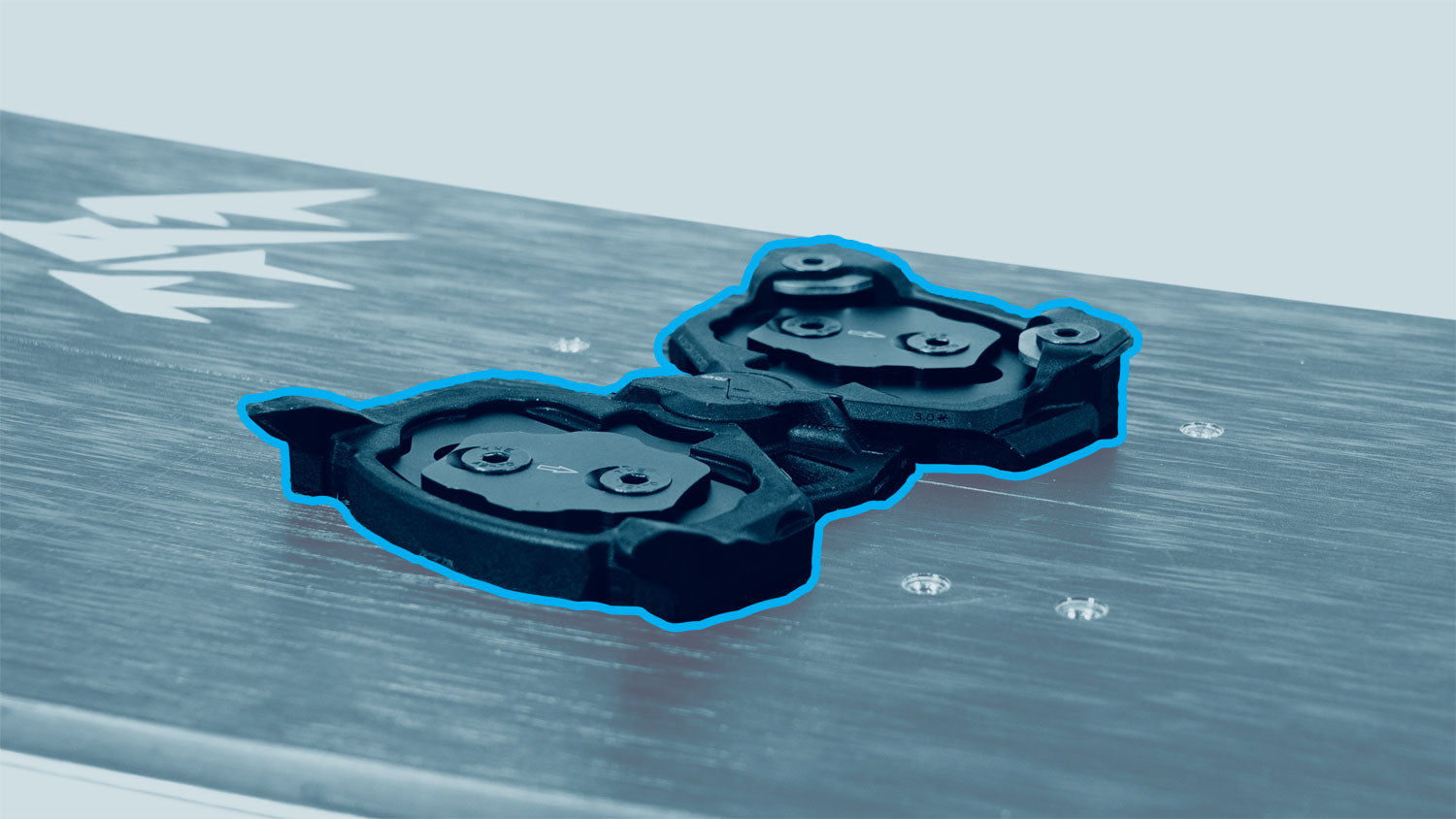 Black plastic snowboard binding discs highlighted on board surface
