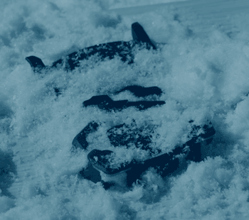 Boot tread footprint pressed into snow, blue-tinted close-up
