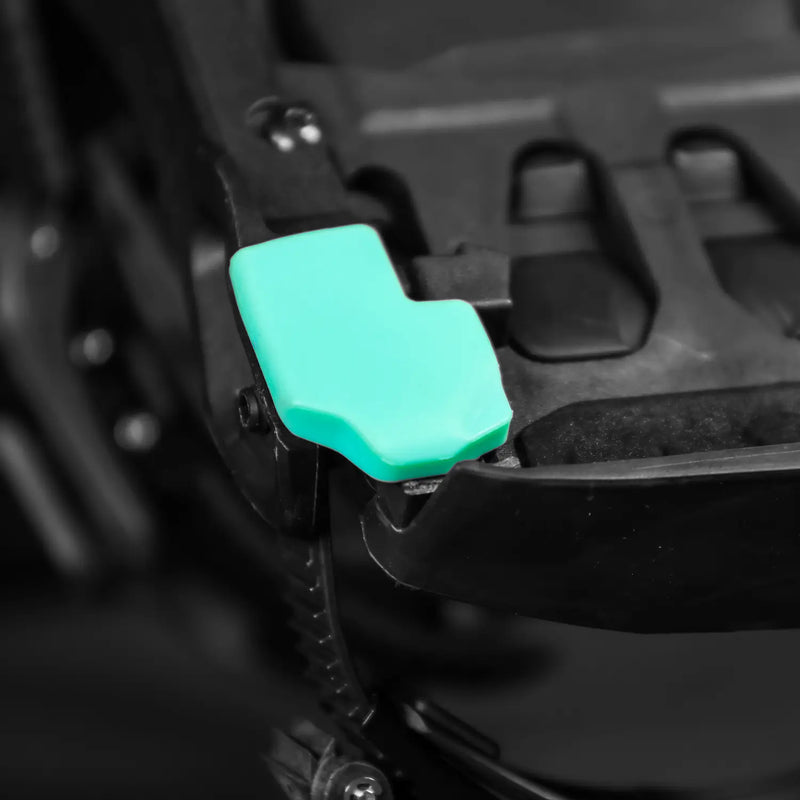 Teal rubber lever cover on black bicycle brake mechanism, close-up