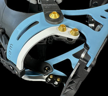 Close-up of blue ski touring binding heel piece with gold hardware